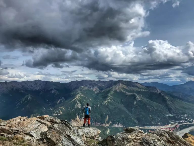Rui stands on a rocky mountain peak along Mount Healy Overlook Trail, overlooking Denali National Park